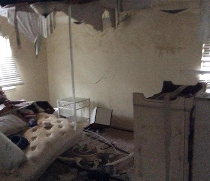 caved in ceiling in bedroom with soiled mattress