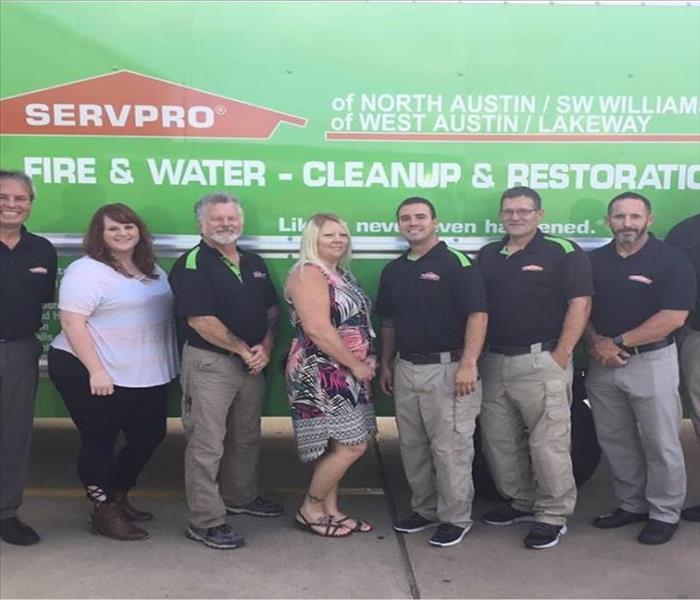 team of employees in from of green SERVPRO truck